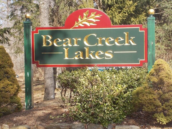 A sign for Bear Creek Lakes with a red maple leaf emblem.