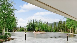Un espace extérieur doté d’un chemin pavé, entouré d’arbres et agrémenté d’un jardin aménagé.