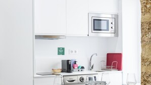 A modern kitchen with a built-in microwave, a Balay coffee machine, a sink, and a red storage box. - El Arco del Fotografo by Cadiz Time (Cádiz)