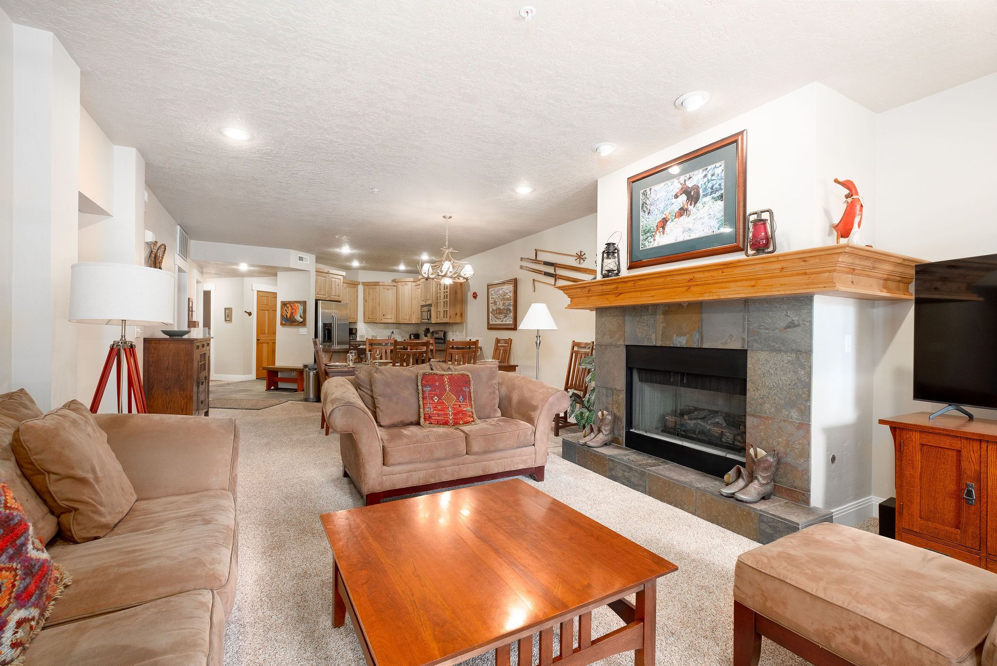 A spacious living room with a fireplace, a sofa, a coffee table, and a television.
