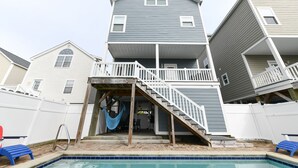 Ein zweistöckiges Haus mit Veranda und Swimmingpool.