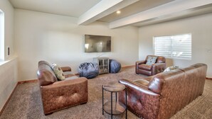 A spacious living room with leather sofas, a coffee table, and a flat-screen TV mounted on the wall. - Book NOW for Summer and Fall Events! In Mountains, 5 mins from Downtown Salida! (Salida)