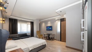 Een hotelkamer met een bed, een televisie, een bureau en een stoel.