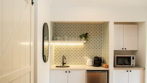 A compact kitchen with a sink, microwave, and dishwasher. - Alcorn Garden-Dog friendly 2 mins walk to beach (Suffolk Park)