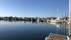 Ein Yachthafen mit vertäuten Booten, ruhigem Wasser und blauem Himmel.