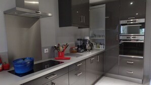 A modern kitchen with stainless steel appliances, grey cabinetry, and a white countertop. - HOUSE with SWIMMING POOL, QUIET AREA NEAR DOWNTOWN LA ROCHELLE (La Rochelle)