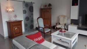 A living room with a sofa, a coffee table, a wooden cabinet, a chair, and a television. - HOUSE with SWIMMING POOL, QUIET AREA NEAR DOWNTOWN LA ROCHELLE (La Rochelle)