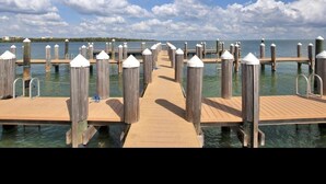 Un muelle de madera que se adentra en aguas tranquilas bajo un cielo despejado.
