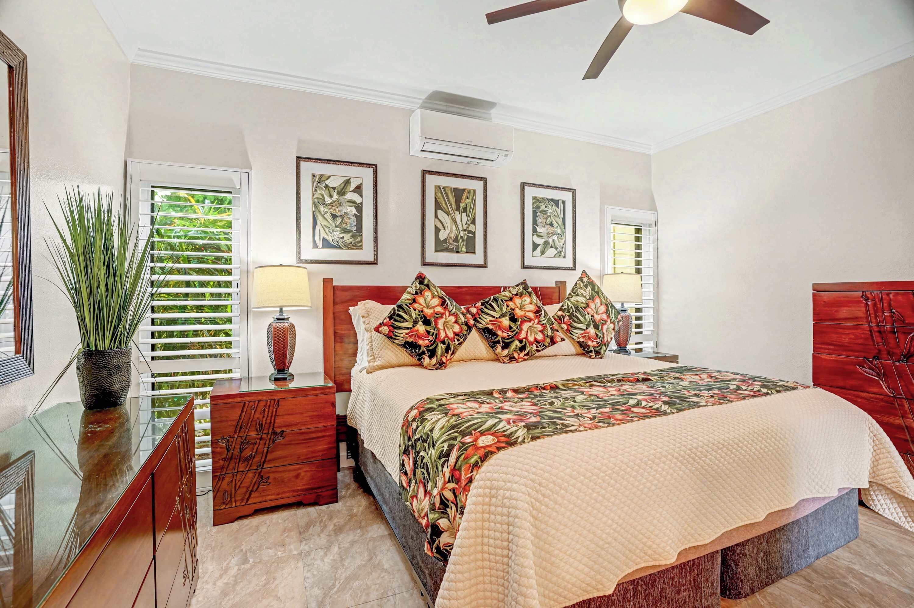 A bedroom with a bed, nightstands, a mirror, and a ceiling fan.