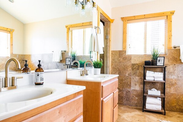 A bathroom with two sinks, wooden cabinets, a towel rack, and a mirror.