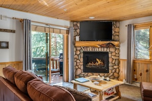 A cozy living room with a stone fireplace, a flat-screen TV, and a comfortable seating area. - Modern 2 floor condo with all the amenities, close to Canyons Village, Sleeps 6 (Park City)