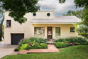 A modern two-story house with a front porch, a garage, and a well-maintained lawn.