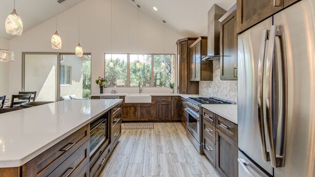 Una cocina moderna con una isla grande, electrodomésticos de acero inoxidable y armarios de madera.