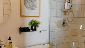 Un baño moderno con inodoro, lavabo y ducha.