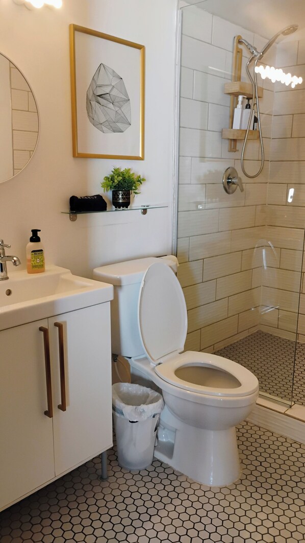 A modern bathroom with a toilet, sink, and shower. - Cozy, spacious off grid cabin. Perfect for 4 adults, or small family. (Joshua Tree)