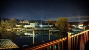 Una propietat a primera línia de mar amb un moll, una casa gran i un cel nocturn clar.