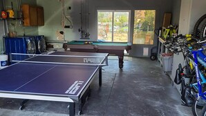 A garage with a ping pong table, a pool table, and a bicycle rack with a blue bike. - Wonderful 3BD 3BA Smarthome w/ multiple decks and large dock! (Clearlake Oaks)