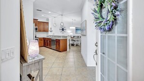 A modern kitchen with wooden cabinets, a central island, and pendant lighting. - Beautiful 3Br/2.5Ba Golf Course Townhome w/Bunk Room for the Kids! (Lakewood Ranch)