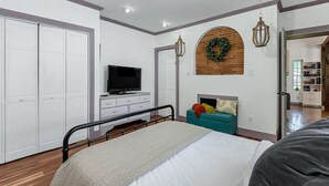 A bedroom with a bed, a TV, a dresser, and a wardrobe. - Norfolk Beach Casita / Fenced Yard / Dog Friendly (Norfolk)