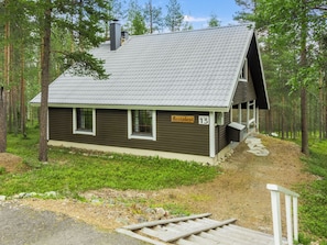 En hytte med skrå tag, en lille veranda og et skilt med navnet 'Kevin's'.