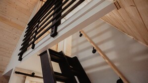 Un intérieur en bois, avec un escalier en métal et un plafond blanc.