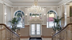 A grand entrance with a chandelier, arched windows, and a black doormat reading "CLUB WYNDHAM".