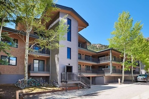 A multi-story building with balconies, a staircase, and bicycles parked outside.