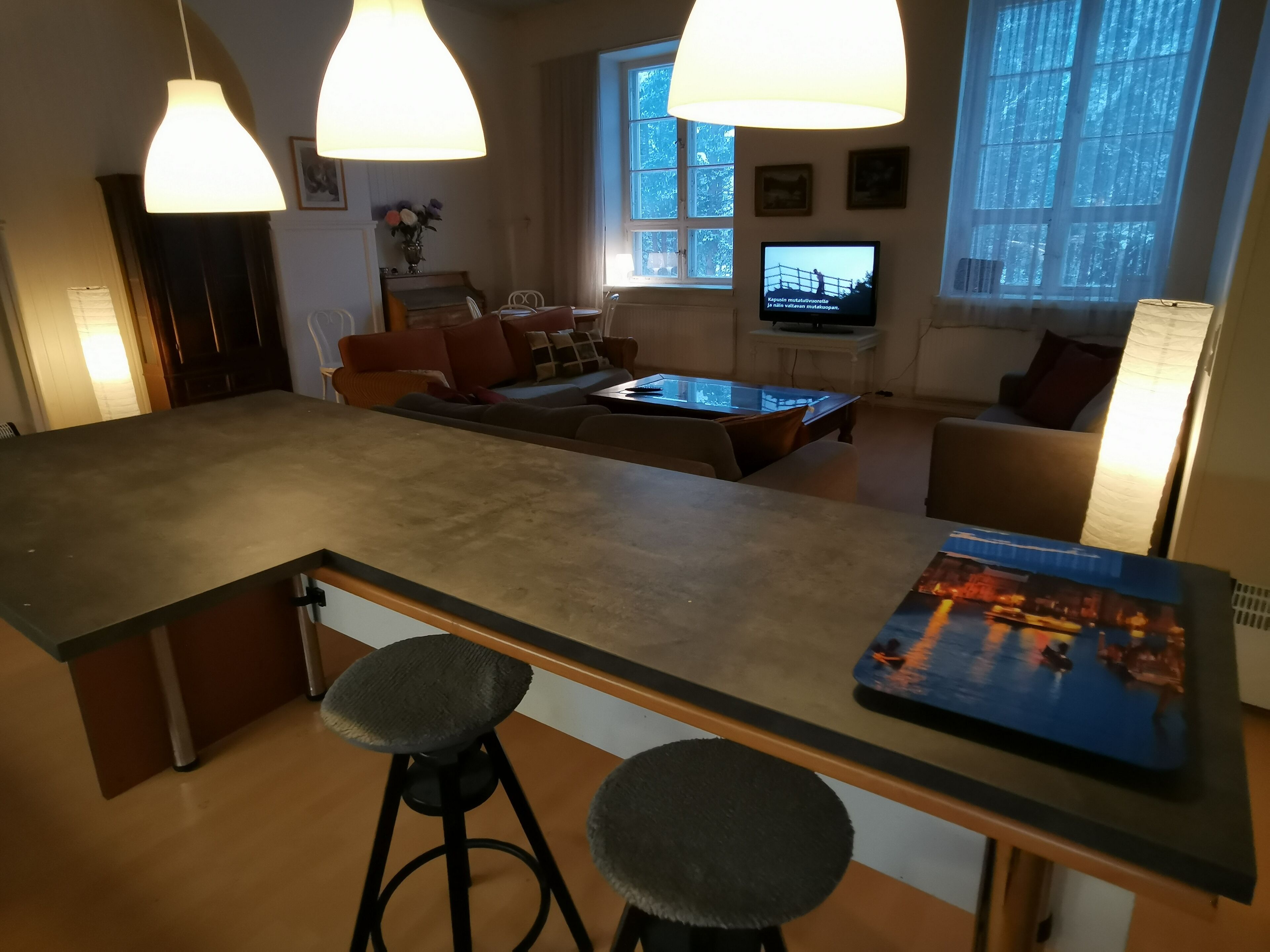 Una cocina moderna con una isla central, taburetes de bar e iluminación colgante.