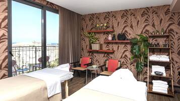 Two single beds with crisp white linens, a city view, and a cozy seating area.