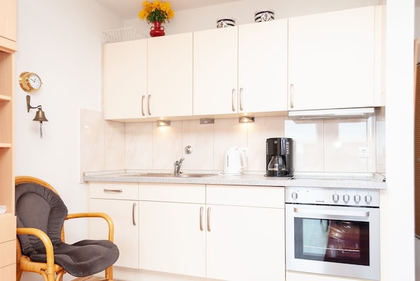 Een koelkast, een oven, een koffiezetapparaat/waterkoker, een waterkoker