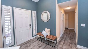 A hallway with a bench, a mirror, and a door with blinds. - Cozy 3BR Home with Pool & Spa - 9 Mi to LV Strip! (Henderson)