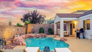 A backyard with a swimming pool, lounge chairs, and a barbecue area. - Royal Skyline -Spacious & Modern 3BR w Pool (Henderson)