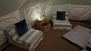 A cozy tented room with two beds, a small wooden nightstand, and a crochet rug. - Spacious Bell Tent at Herigerbi Park, Lincolnshire (Grantham)