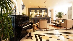 A grand lobby with a black grand piano, a bar area, and seating arrangements. - Rasim Palas (Adults Only +12) (Cesme)