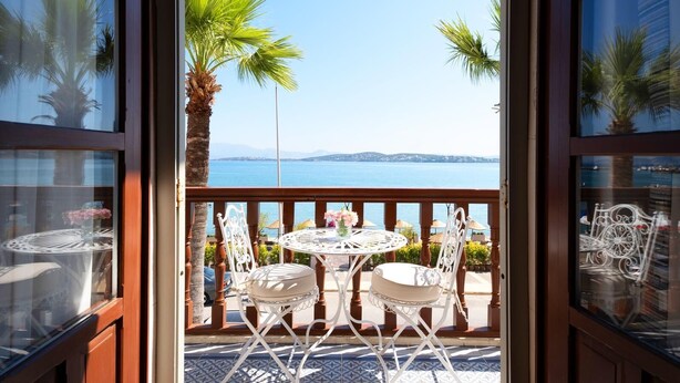 An open balcony with a table and chairs, overlooking a body of water and distant land. - Rasim Palas (Adults Only +12) (Cesme)
