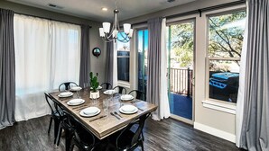 Comedor con una mesa de madera dispuesta para seis personas, rodeado de sillas negras.