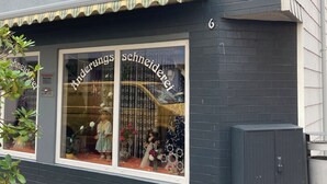 Un escaparate con un amplio ventanal que muestra maniquíes y arreglos florales.