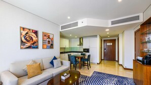 Een moderne woonkamer met een bank, salontafel en kunstwerk aan de muur.