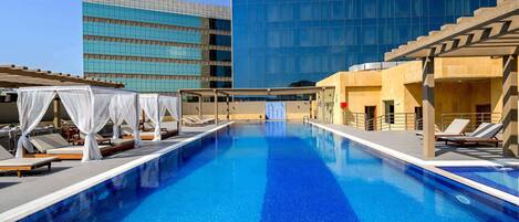 Alberca al aire libre, sombrillas en la alberca y camastros