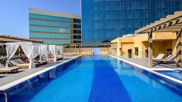 Una piscina al aire libre, sombrillas, tumbonas