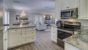 A modern kitchen with white cabinetry, a built-in oven, and a microwave.