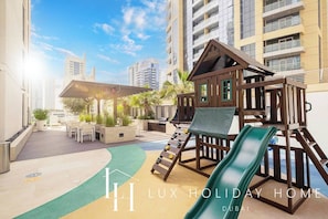 Relax in a spacious outdoor oasis with a play structure, seating area, and lush garden.