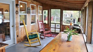 A wooden interior with rocking chairs, a wooden table, and a potted plant. - "Andy's Place" (Abbot)