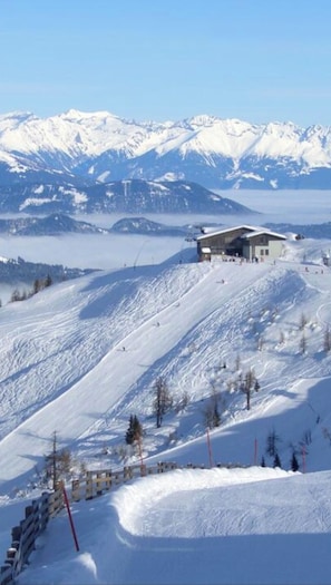 Et snedækket bjerg med en skiferiebygning og stolelift i baggrunden.