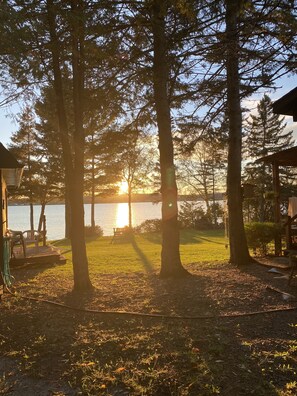 A lakeside property with a deck, chairs, and a gazebo. - Island Escape on Long Lake with beautiful views on Long Lake. (Saint Agatha)
