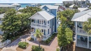 A coastal residential area with a prominent two-story house featuring a balcony and a view of the ocean. - Periwinkle - Sunrise Beach on 30A, Heated Private Pool, Free Beach Service! (Santa Rosa Beach)