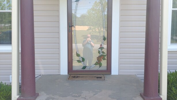 A front entrance with a glass door, a decorative wreath, and steps leading up to the porch. - Historic Seneca Bungalow (Seneca)