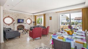 A spacious living area with a fireplace, comfortable seating, and a dining area with a table set for a meal. - 4 Ensuite Bedrooms Private Heated Outdoor Pool (Mugla)