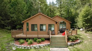 Eine Holzhütte mit einer Holzterrasse, einer Veranda und einer kleinen Sitzecke im Freien.