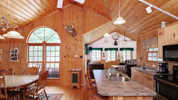 Ein Holzblockhaus-Interieur mit Essbereich, Küche und Wohnbereich.
